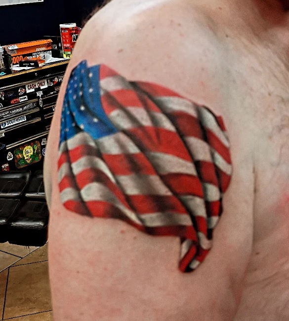 Photorealistic color American flag tattoo on shoulder