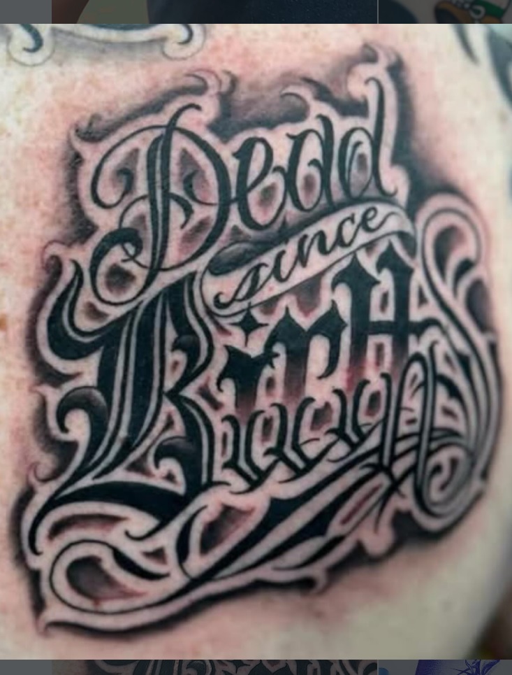 Bold custom black script lettering tattoo