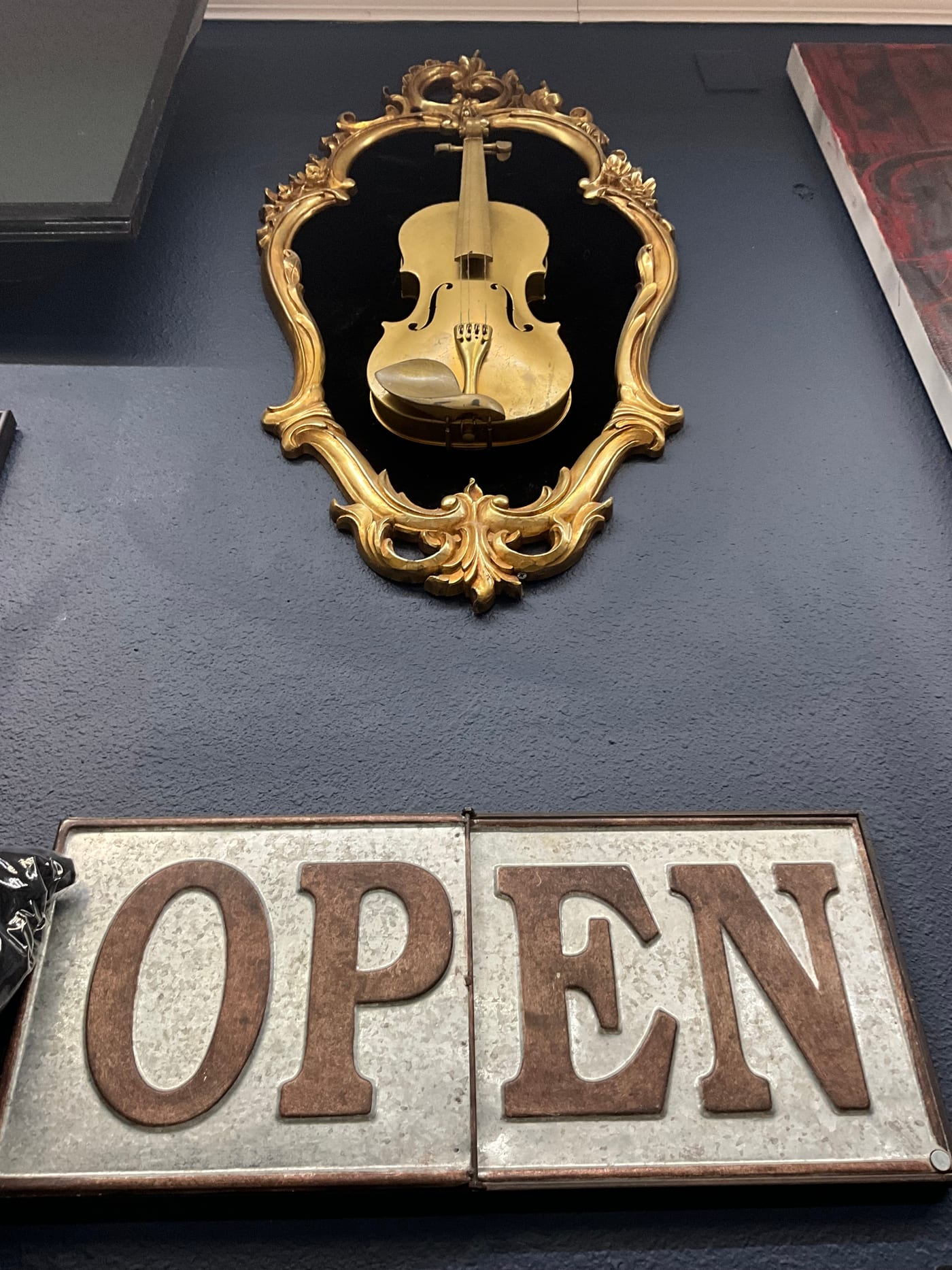 Decorative gold violin and vintage OPEN sign inside I-45 Ink